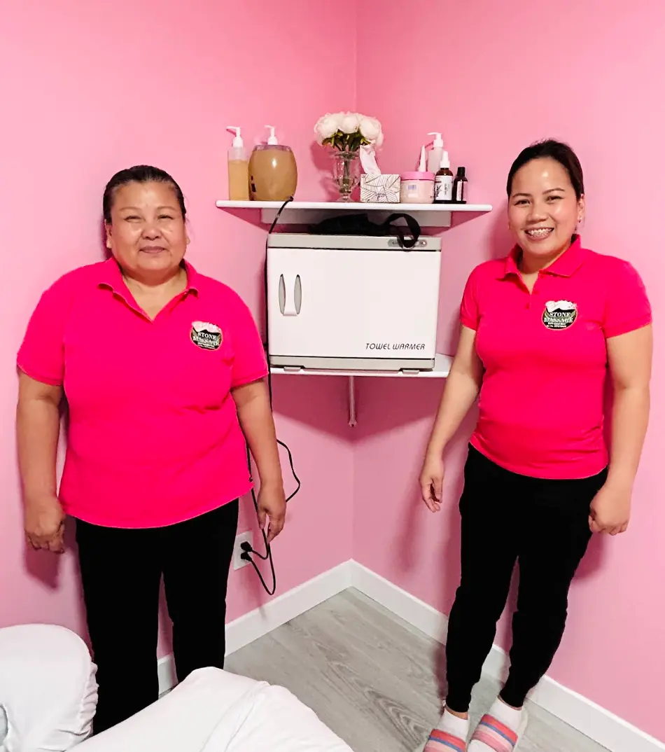 Stone Massage therapists beside the towel warmer in a treatment room