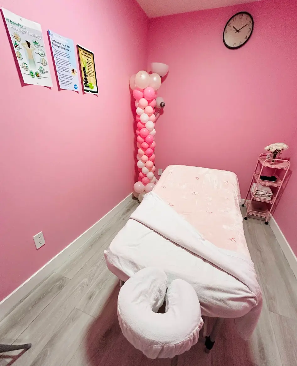 Private massage room with a prepared treatment table and pink decor