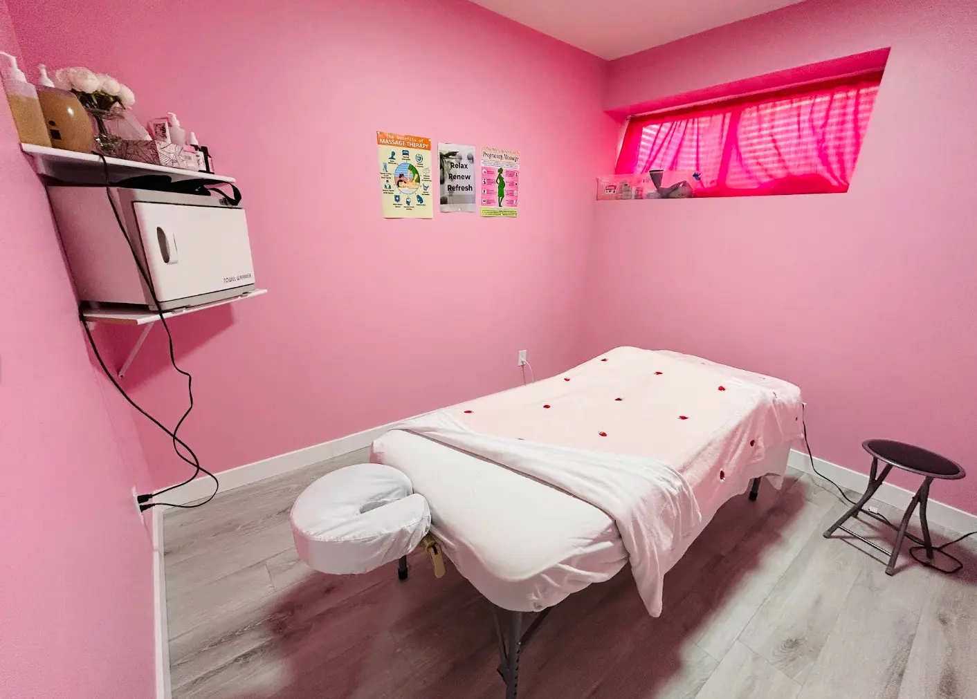 Pink massage treatment room with a prepared therapy table